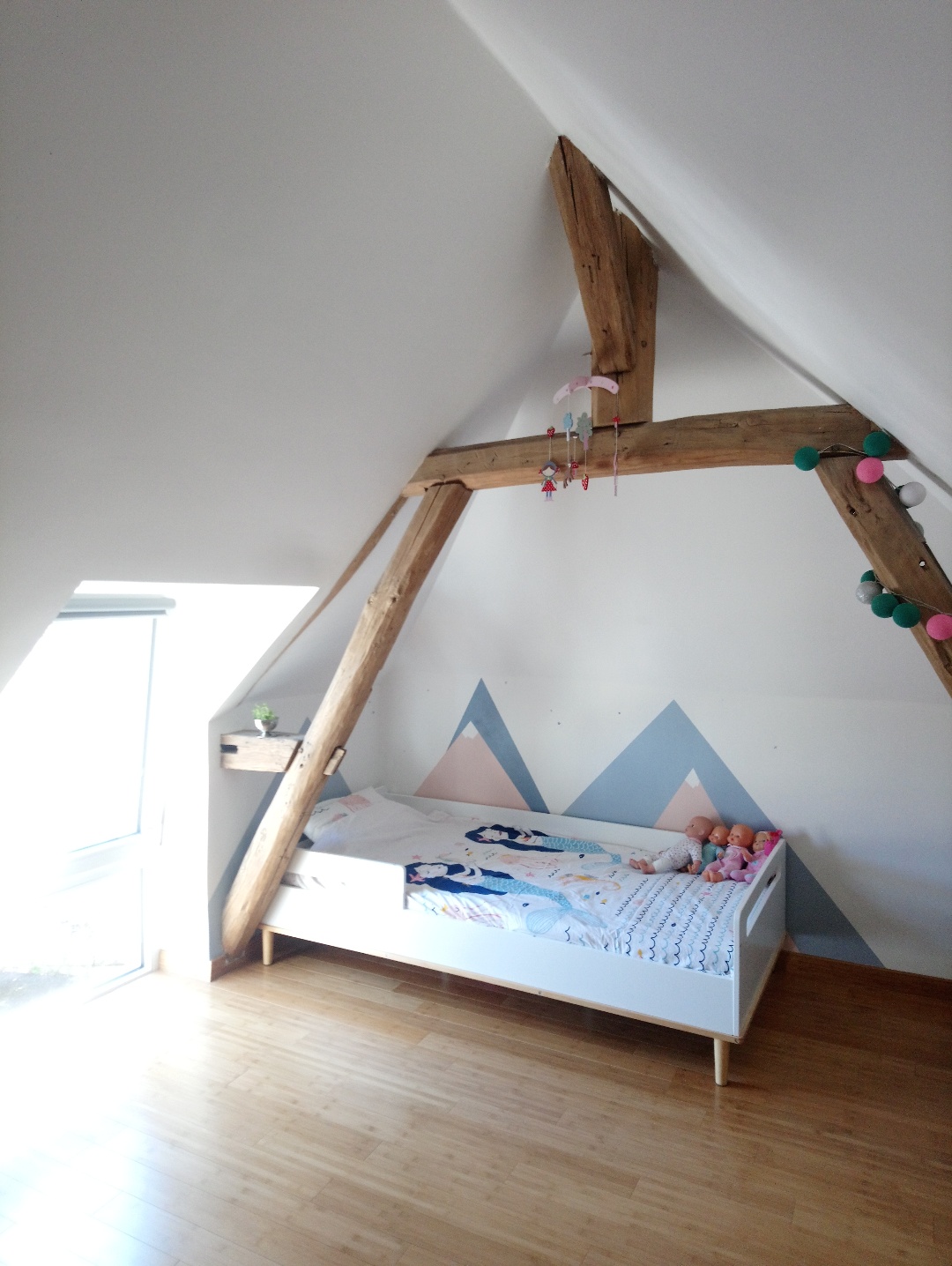 chambre d'enfant avec peinture montagne au mur, chambre petite fille sous les combles, lumineuse, parquet, poutre apparente